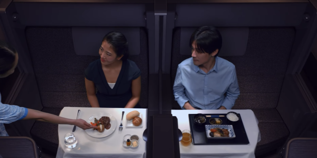 a man and woman sitting at a table with food