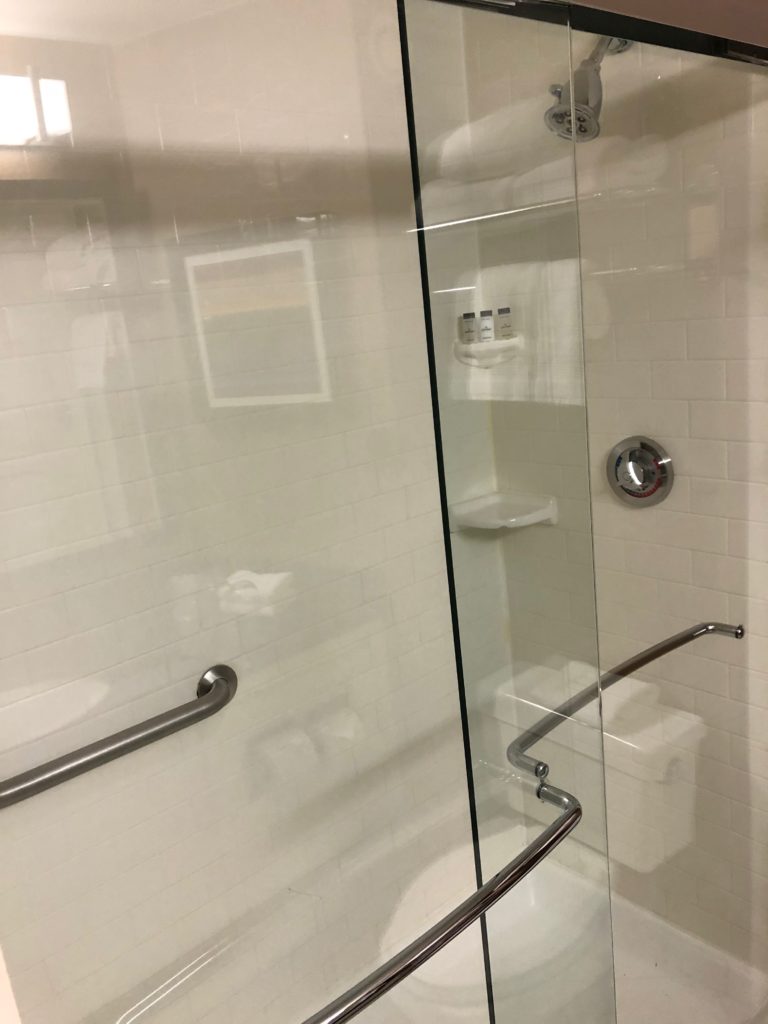 a glass shower door with a toilet and a toilet