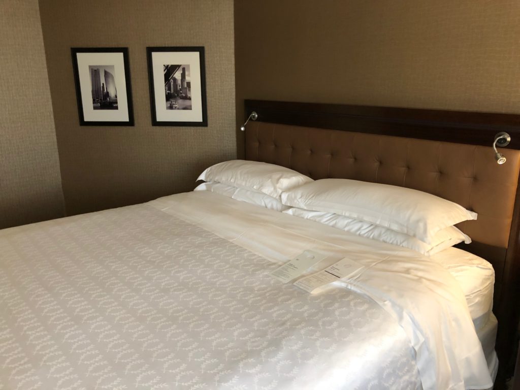 a bed with white sheets and pillows