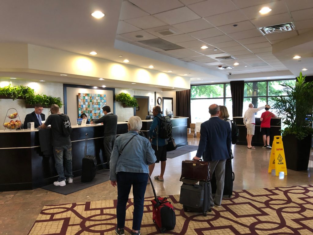 a group of people standing around a counter in a hotel