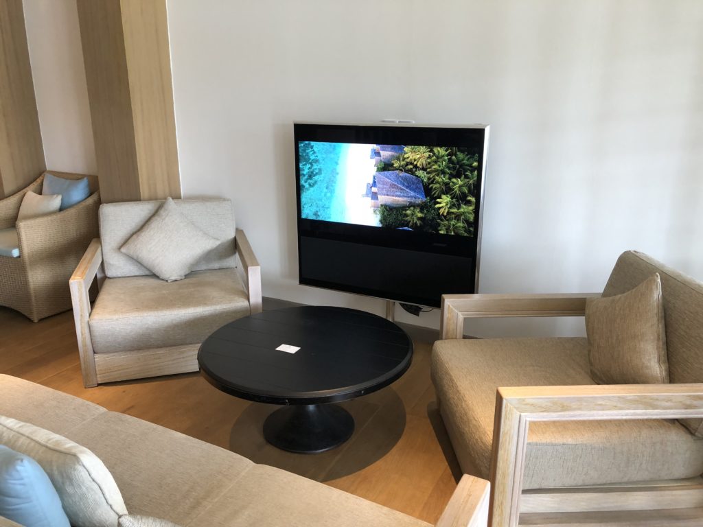 a living room with a television and chairs