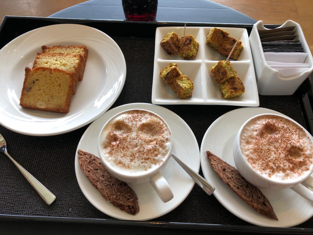 a tray with plates of food and cups of coffee