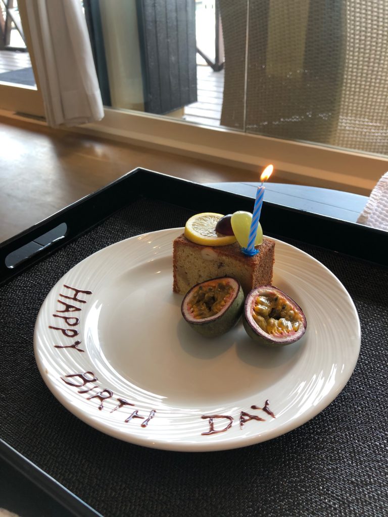 a plate with a piece of cake and a lit candle on it