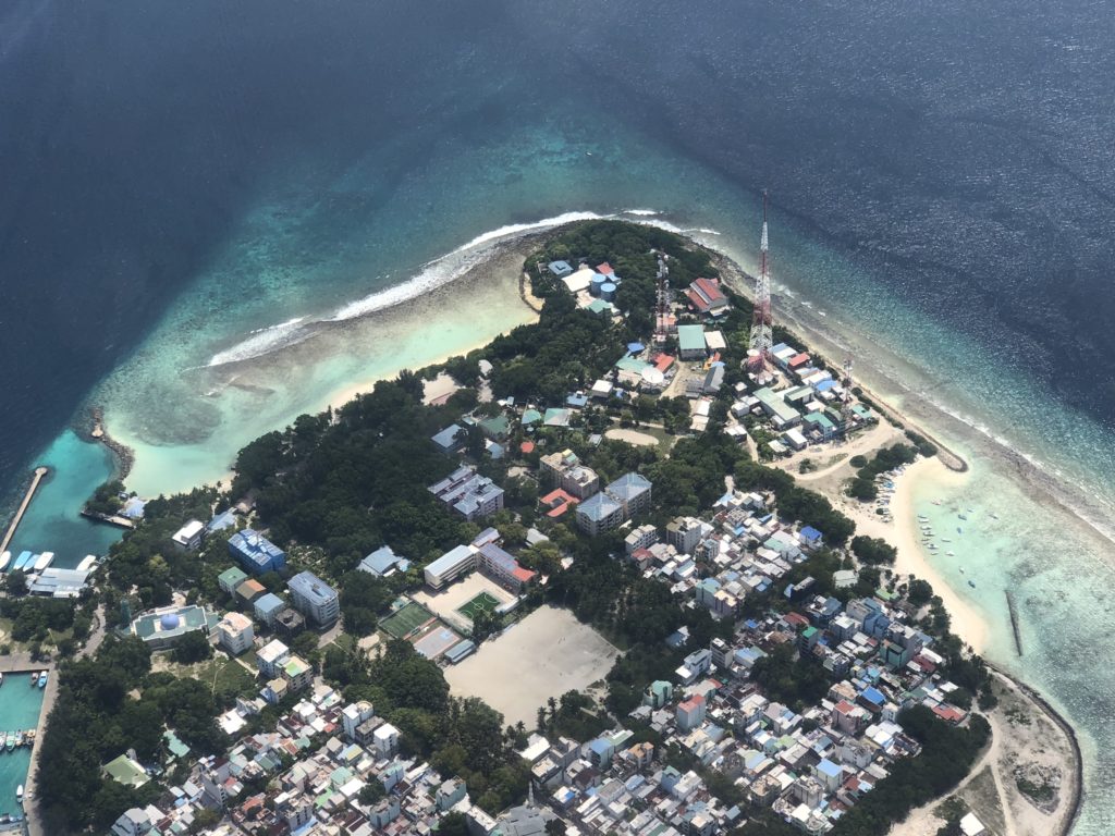 an aerial view of a small island with buildings and a beach