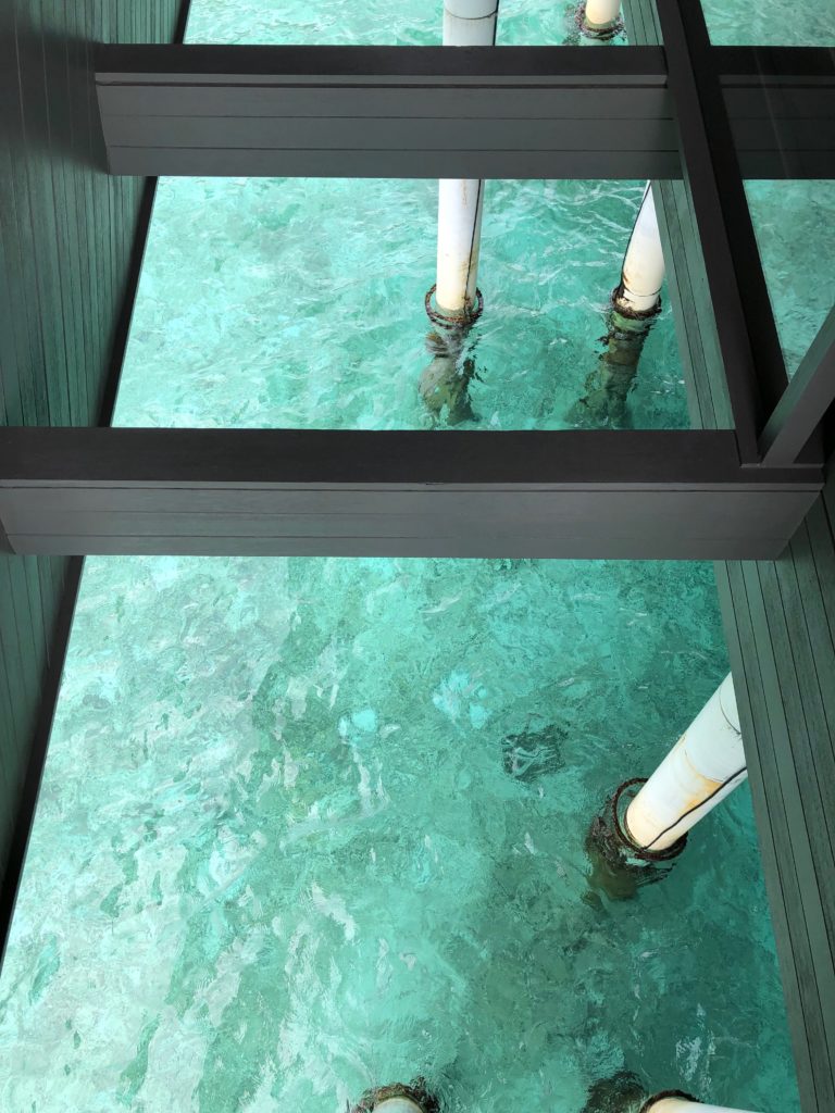 a view from a deck of a building with a clear blue water