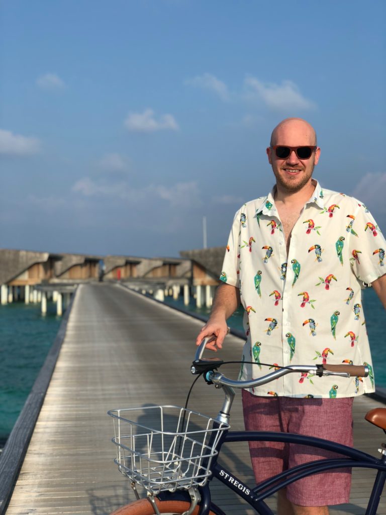 a man standing on a bridge with a bicycle