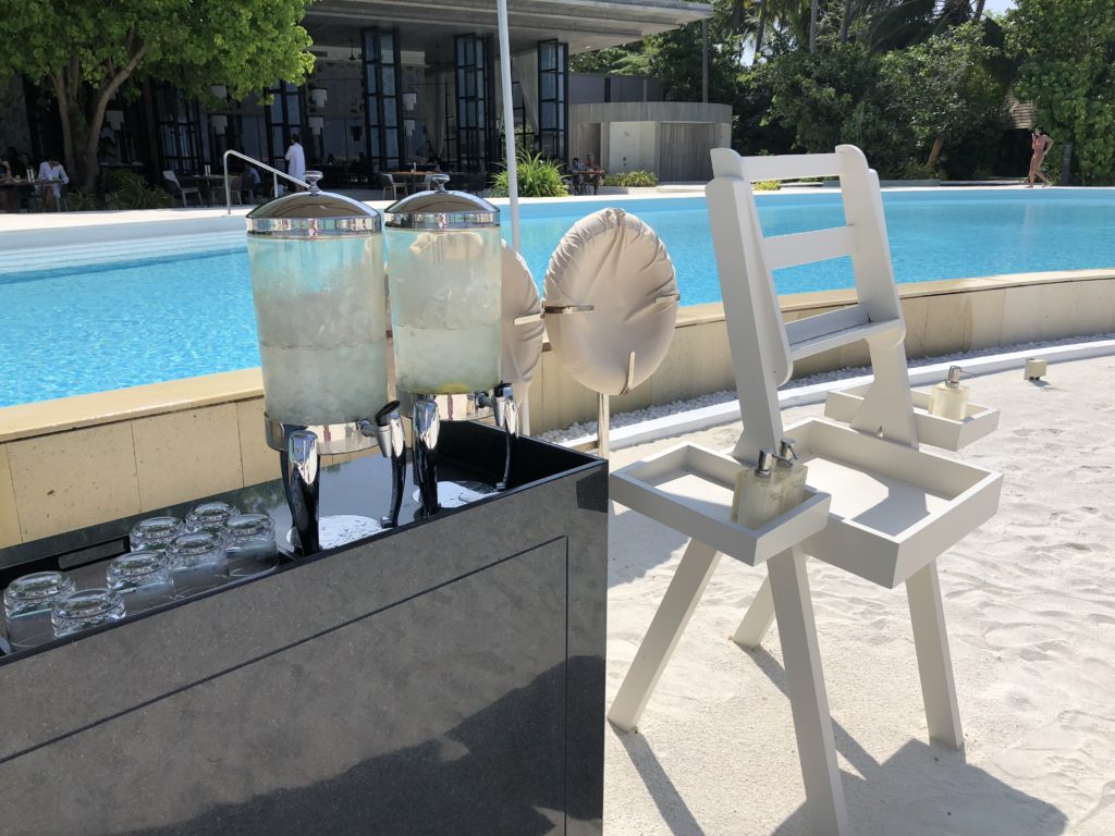 a water dispenser and chairs next to a pool