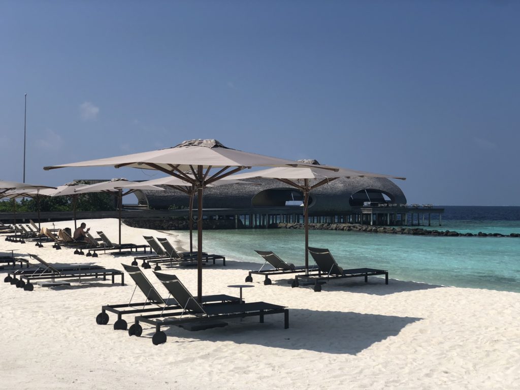 a beach with chairs and umbrellas