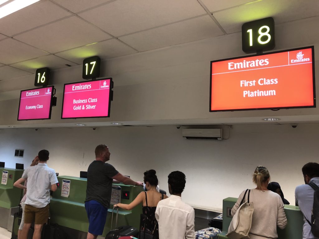 people standing in front of a counter with signs and numbers