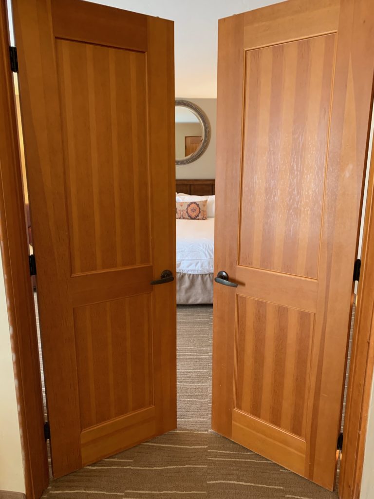 a double door with a bed in the background