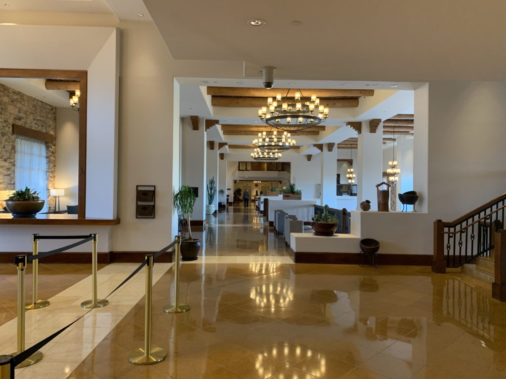 a hallway with a chandelier and a mirror