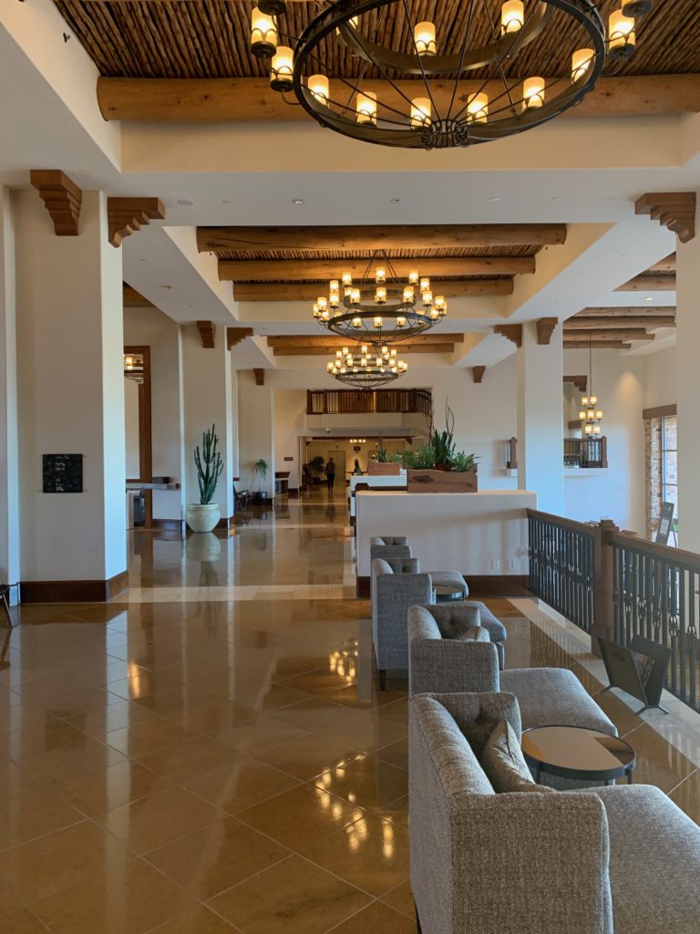 a large lobby with a chandelier and chairs