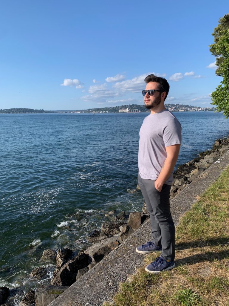 a man standing on a ledge by a body of water