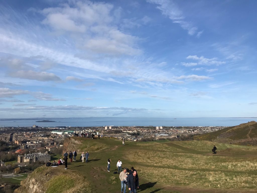 a group of people on a hill with a city in the background