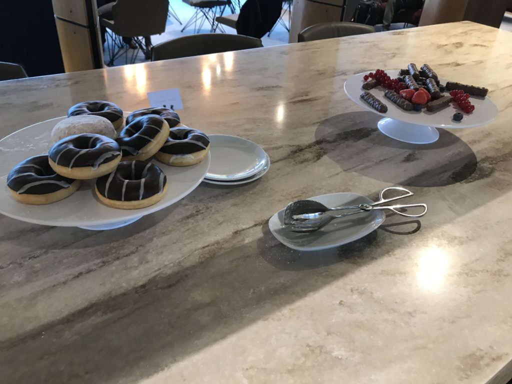 a plate of donuts and a plate of sausages on a table