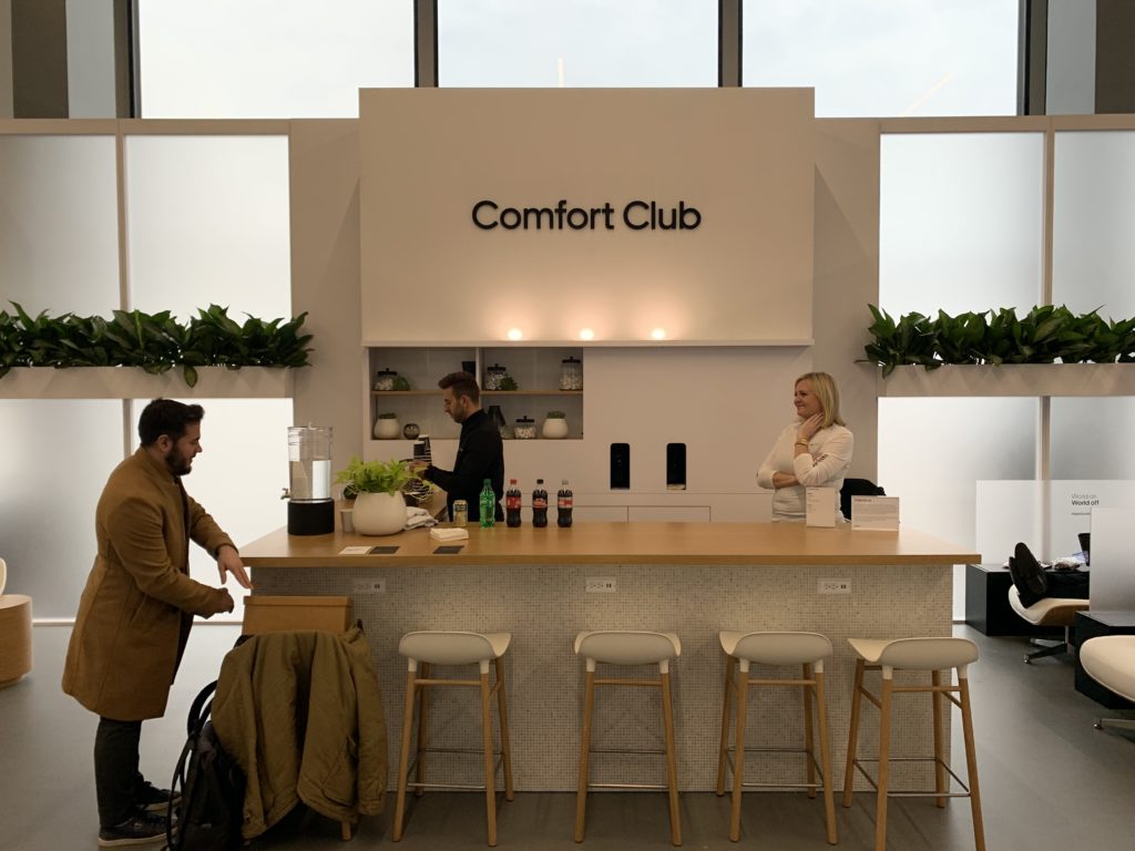 a man and woman standing at a counter in a room with windows