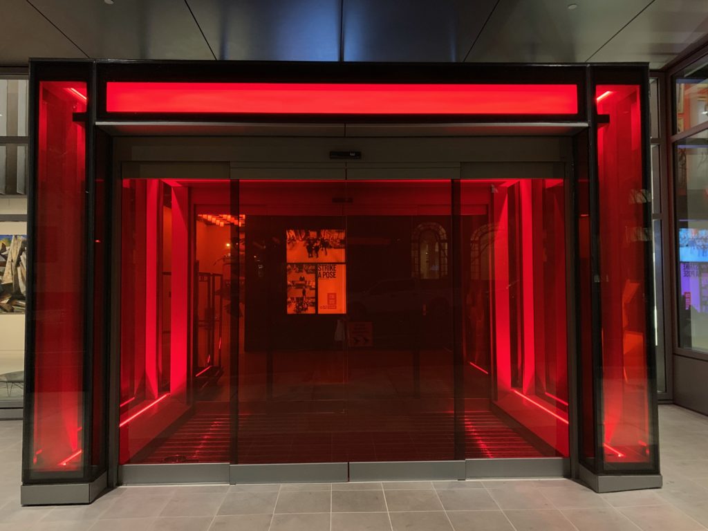 a glass doors with red lights with Fushimi Inari-taisha in the background