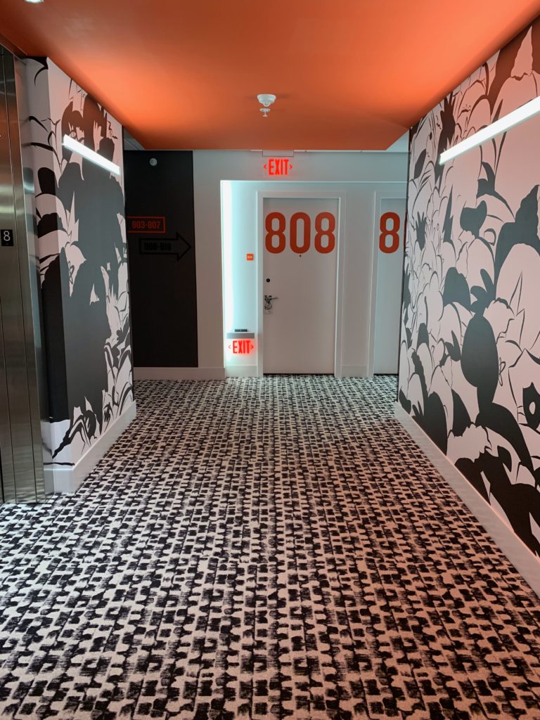 a hallway with a white door and black and white patterned carpet