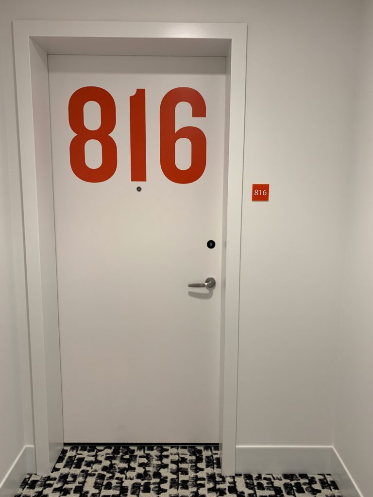 a white door with red numbers and a silver handle