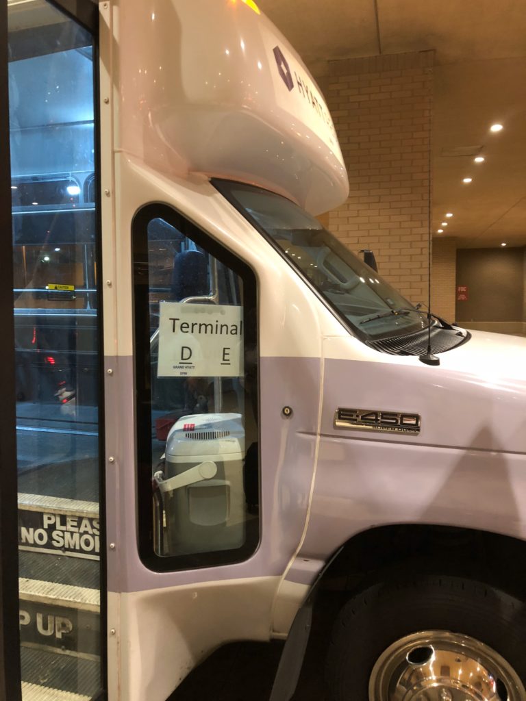 a white and purple bus with a sign on the door