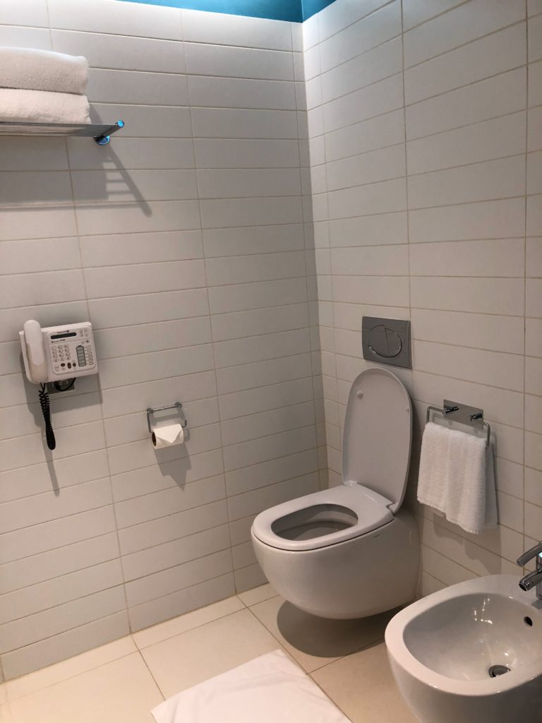 a bathroom with a phone and toilet