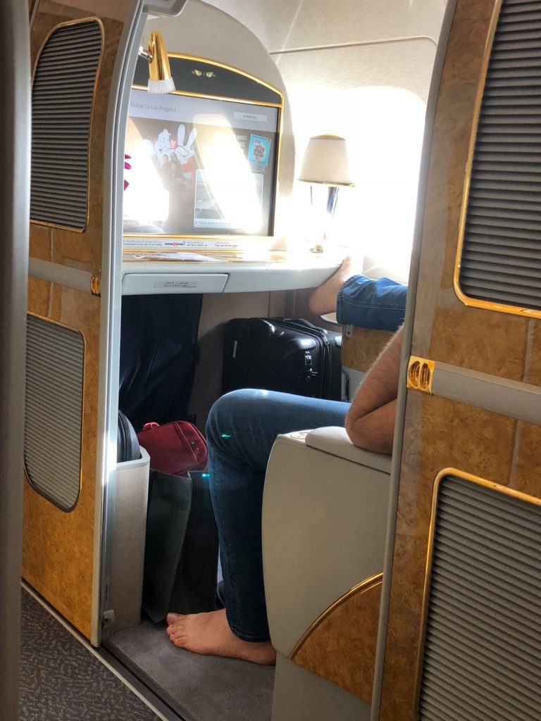 a person sitting in an airplane with a tv