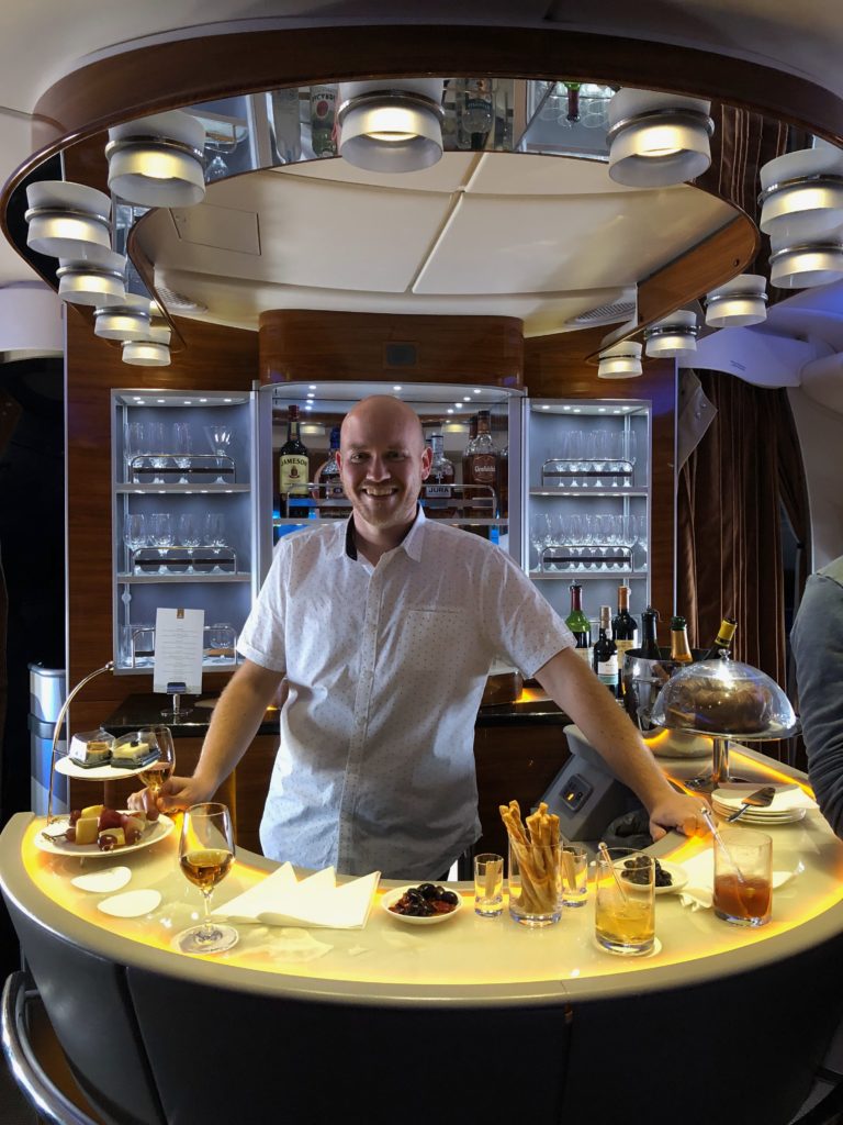 a man standing behind a counter with food on it