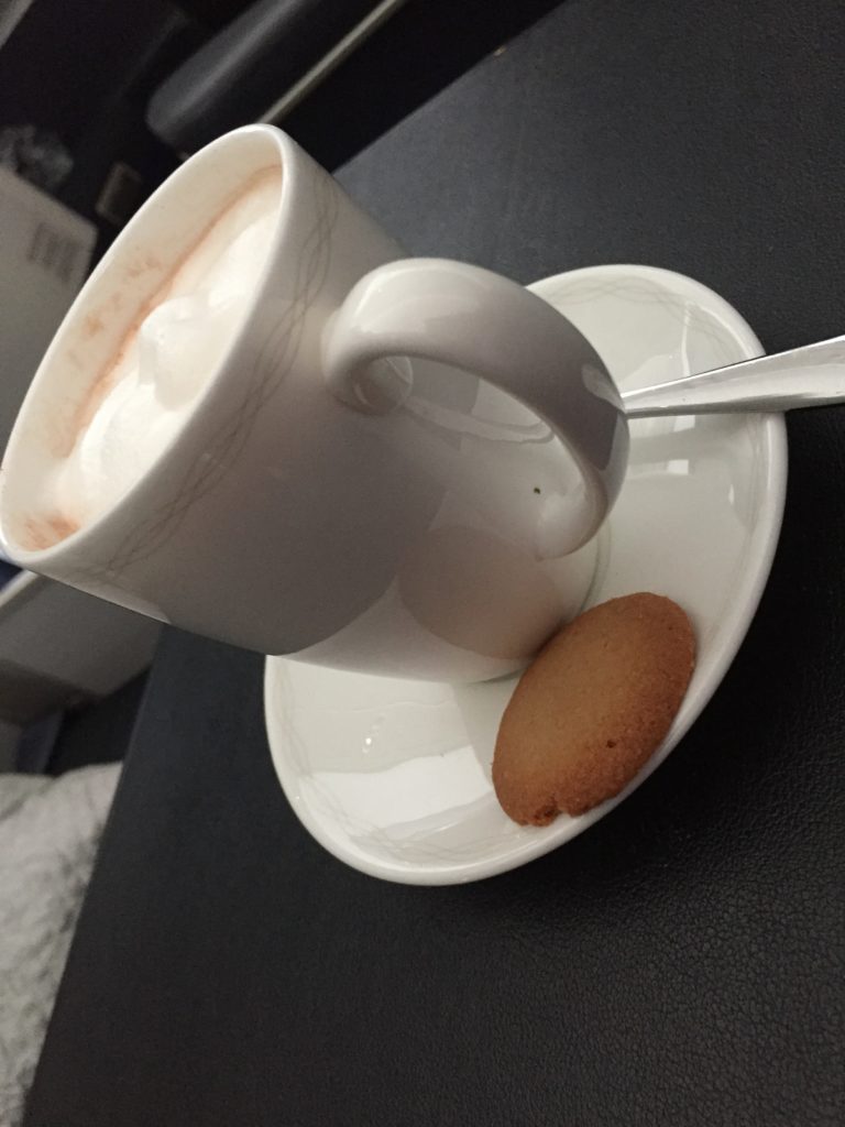 a cup of coffee and a cookie on a saucer