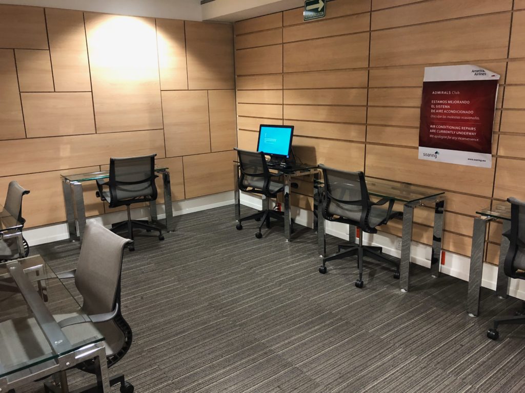 a room with a computer and chairs