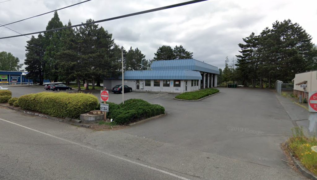 a building with a blue roof and a parking lot