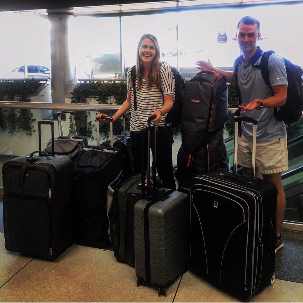 a man and woman standing next to luggage