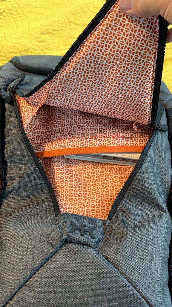 a grey and orange backpack with a white and orange patterned inside