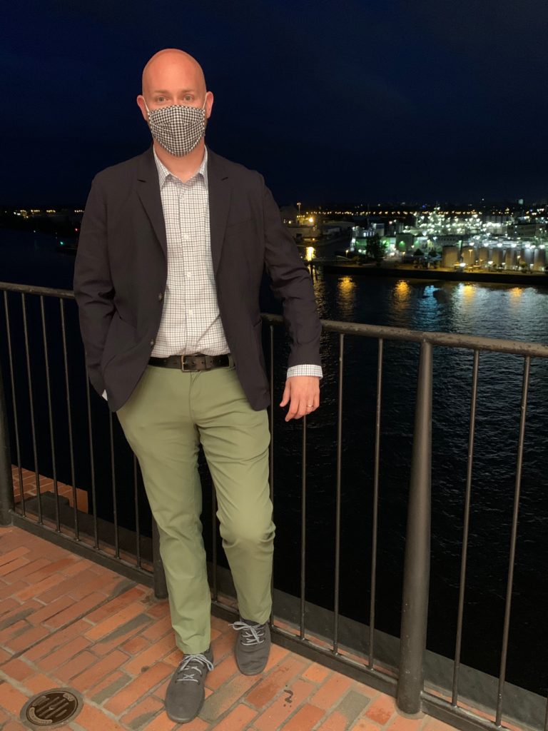 a man wearing a mask and standing on a railing