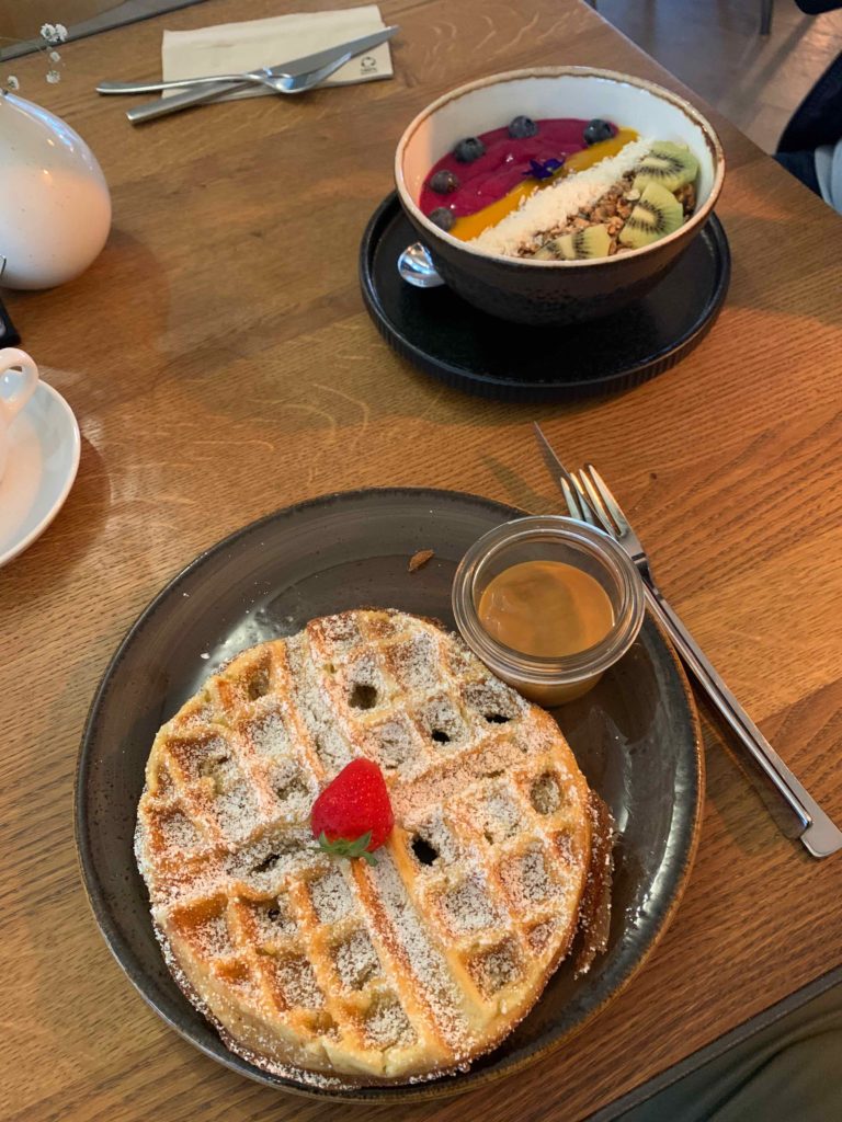 a waffle and a bowl of fruit