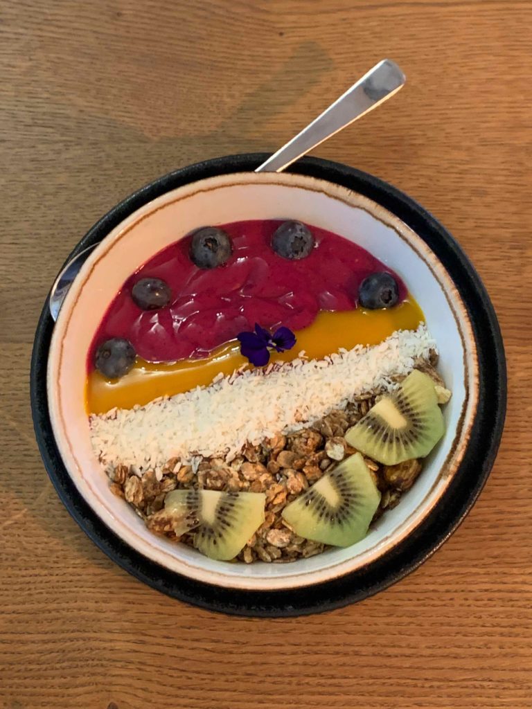 a bowl of fruit and yogurt with a spoon
