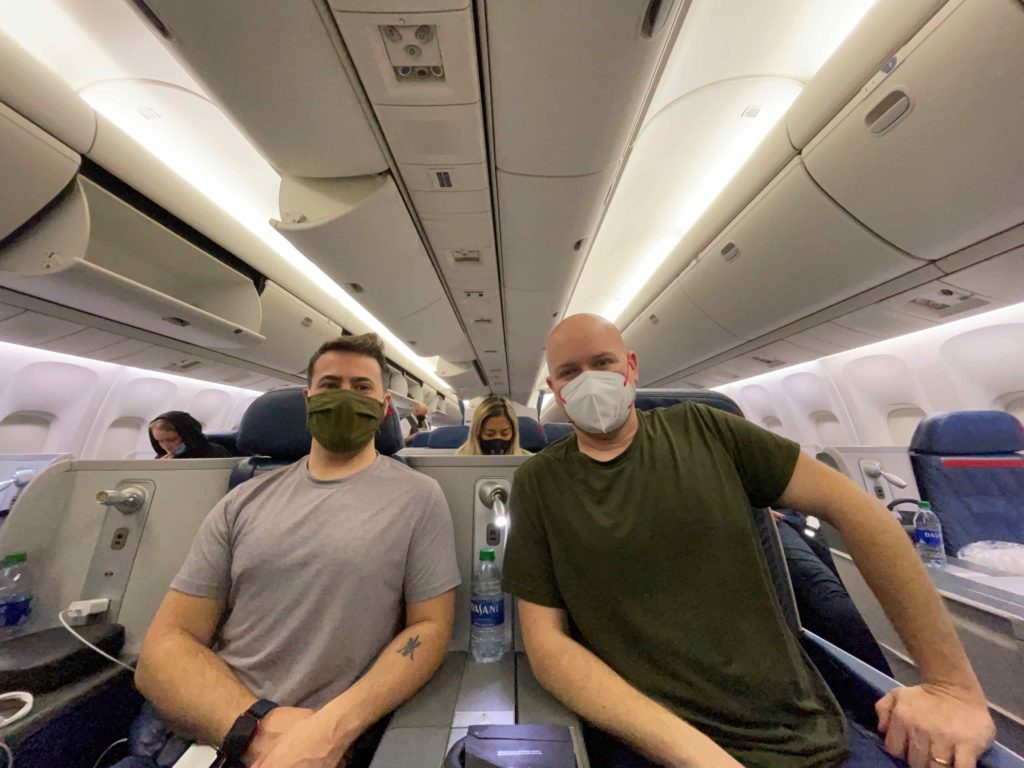 two people wearing face masks on an airplane