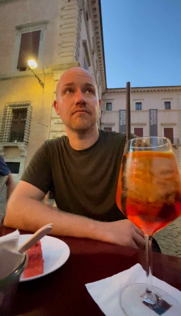 a man sitting at a table with a drink