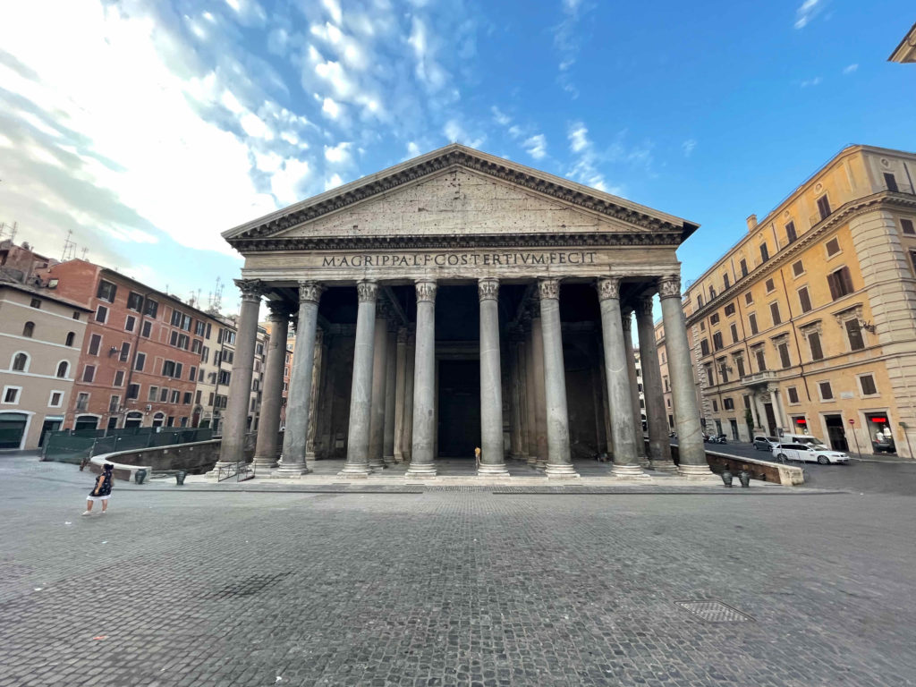 a building with columns and a brick road