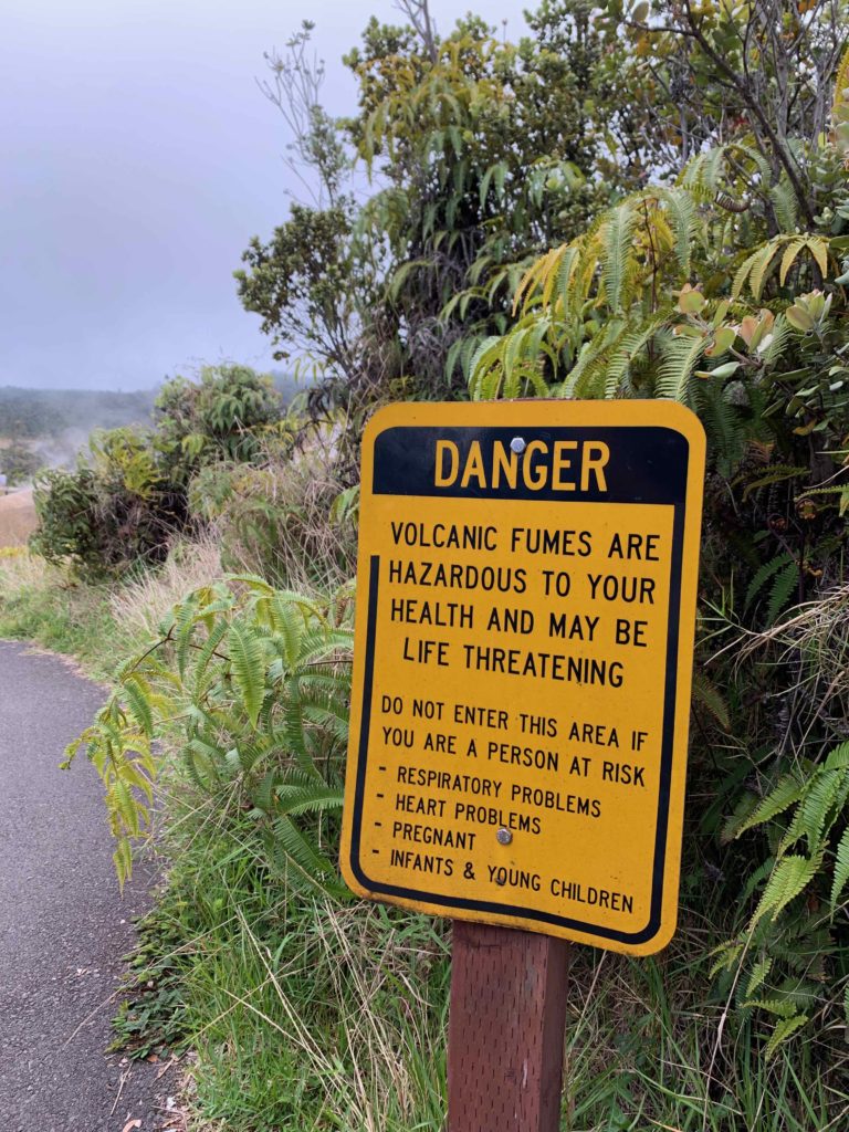 a yellow sign on a trail