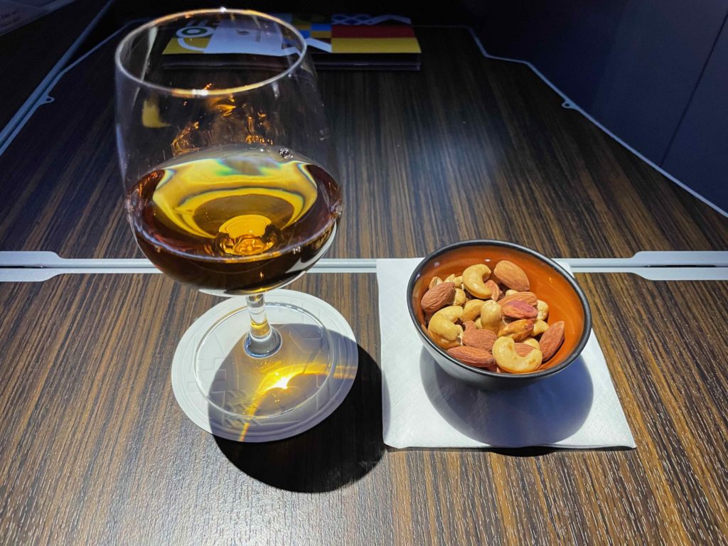 a glass of wine and nuts on a table
