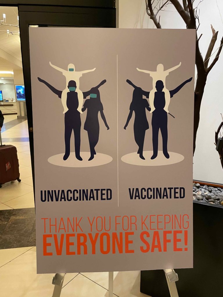 a sign with people wearing masks