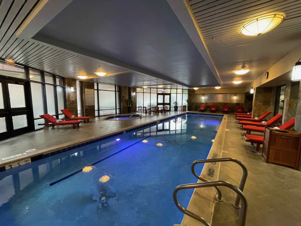 a pool with chairs in a room