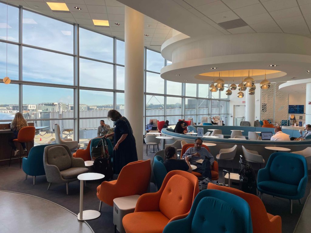 a group of people sitting in a room with large windows