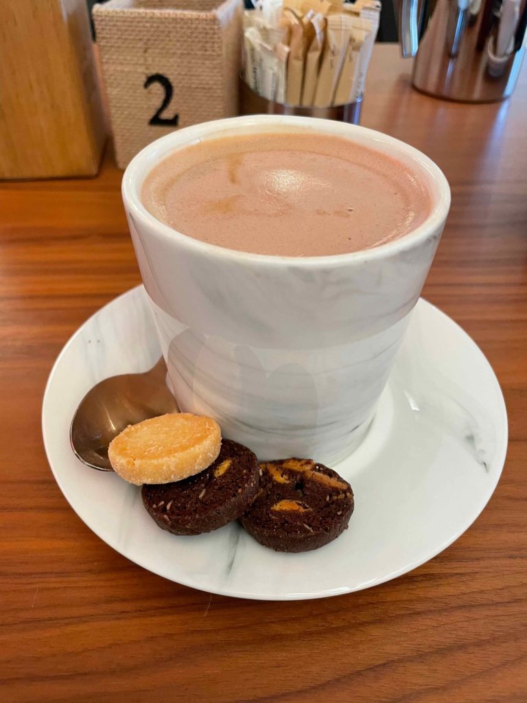 a cup of hot chocolate and cookies on a plate