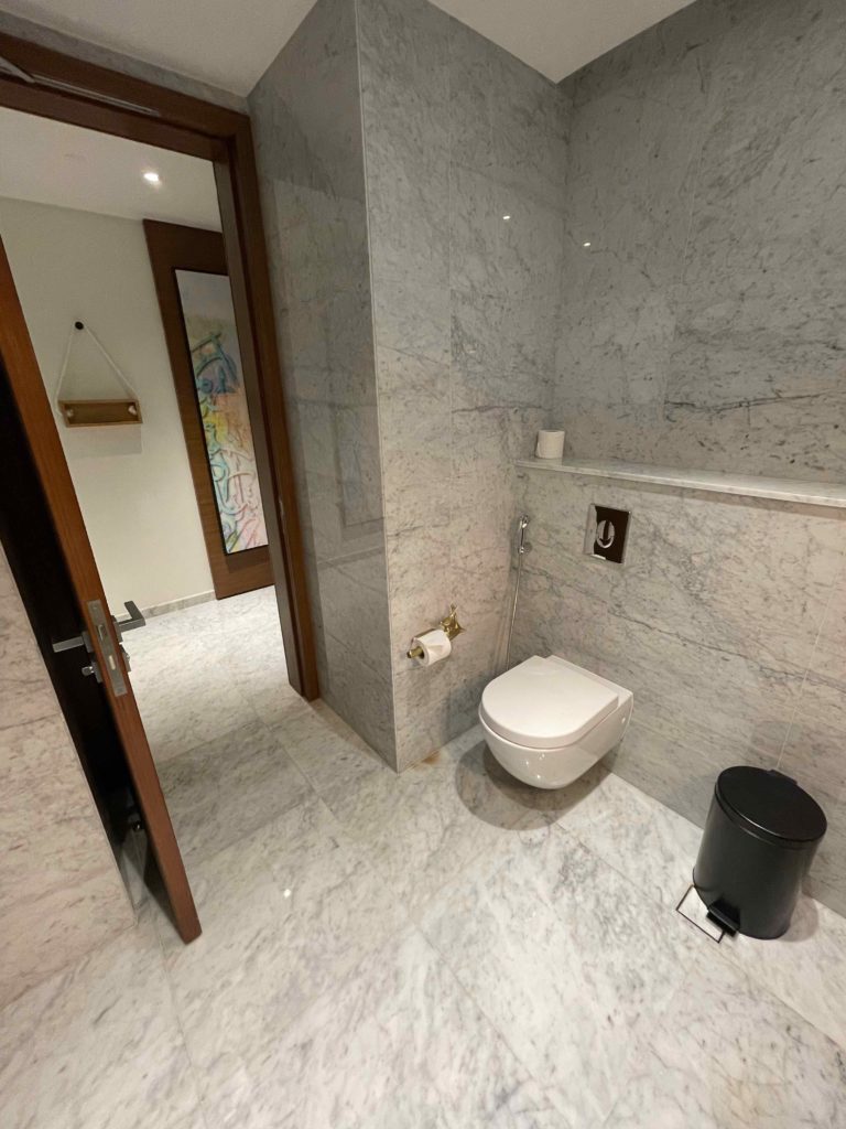 a bathroom with marble walls and a toilet