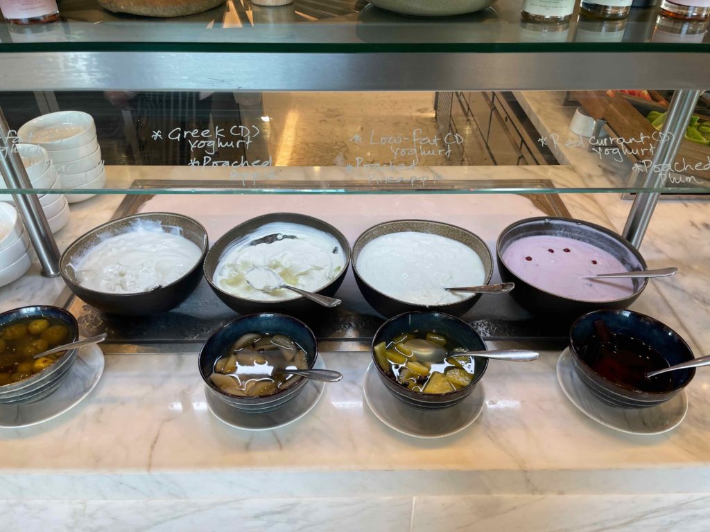 a row of bowls of yogurt and other food